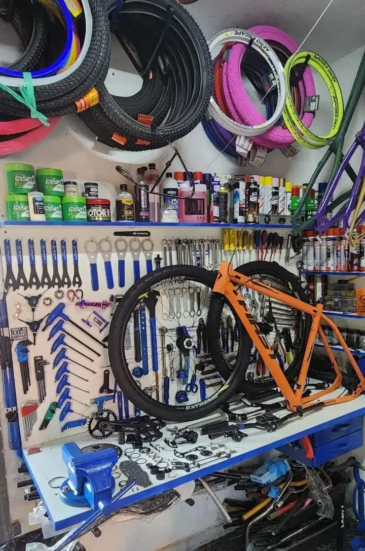 Parede da loja com aros, lubrificantes e peças de bicicleta